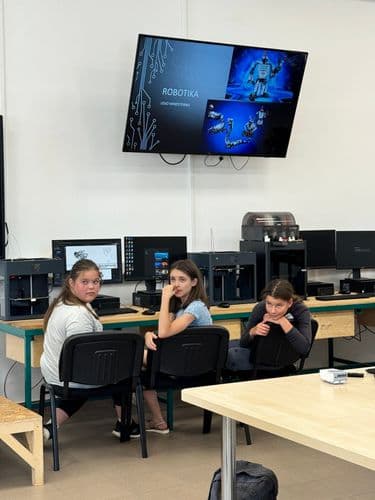 Három lány a számítógépek előtt ül a DKA-ban és robotika témájú programot futtat