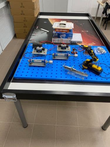 Nagy méretű szerelőasztal, rajta FESTO léghengerek, robotkar és vezérlés