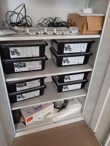 Nyitott ajtajú szekrény dobozokkal, áramköri elmekkel