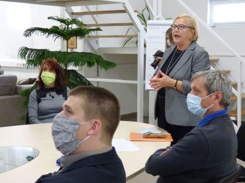Énekes Rita, a Petzelt iskola igazgatója előad a DKA aulájában, a nagy ovális asztal mellett állva